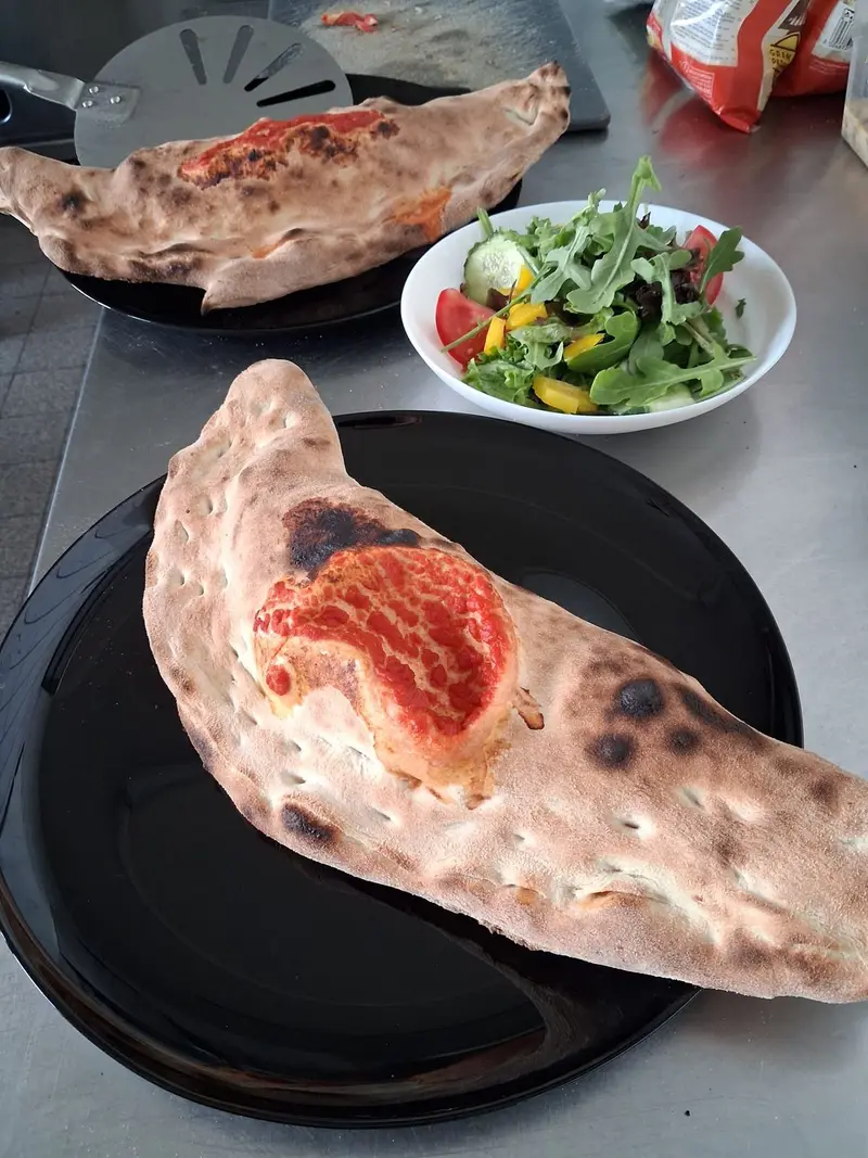 Calzone Regina: Tomatensauce, Mozzarella, Schinken und frische Champignons, geklappt