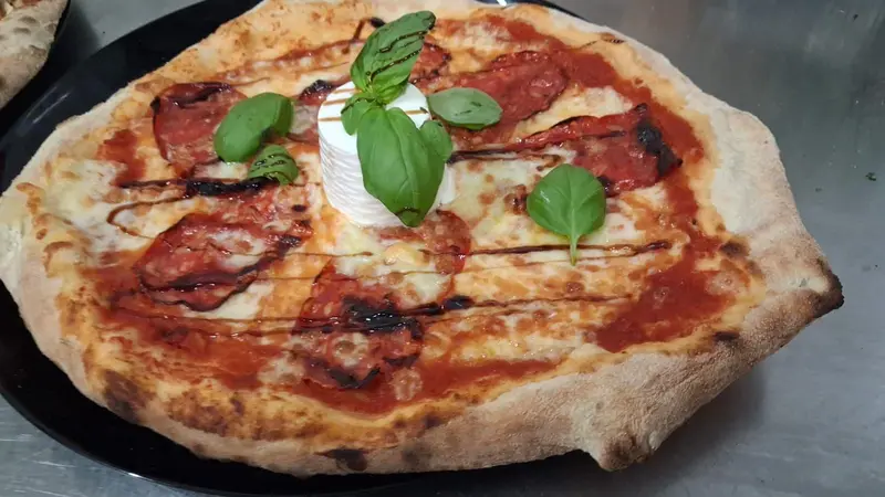 Steinofenpizza mit Burrata und Basilikum, frisch aus dem Ofen