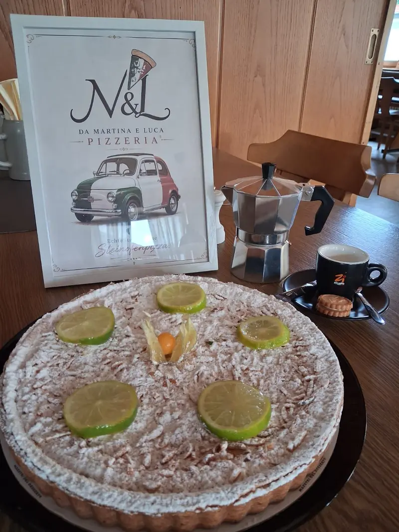 Hausgemachte Limettentorte, daneben Espressokanne und unser M&L-Schild